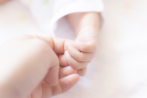 赤ちゃんの手とママが手が触れあっている